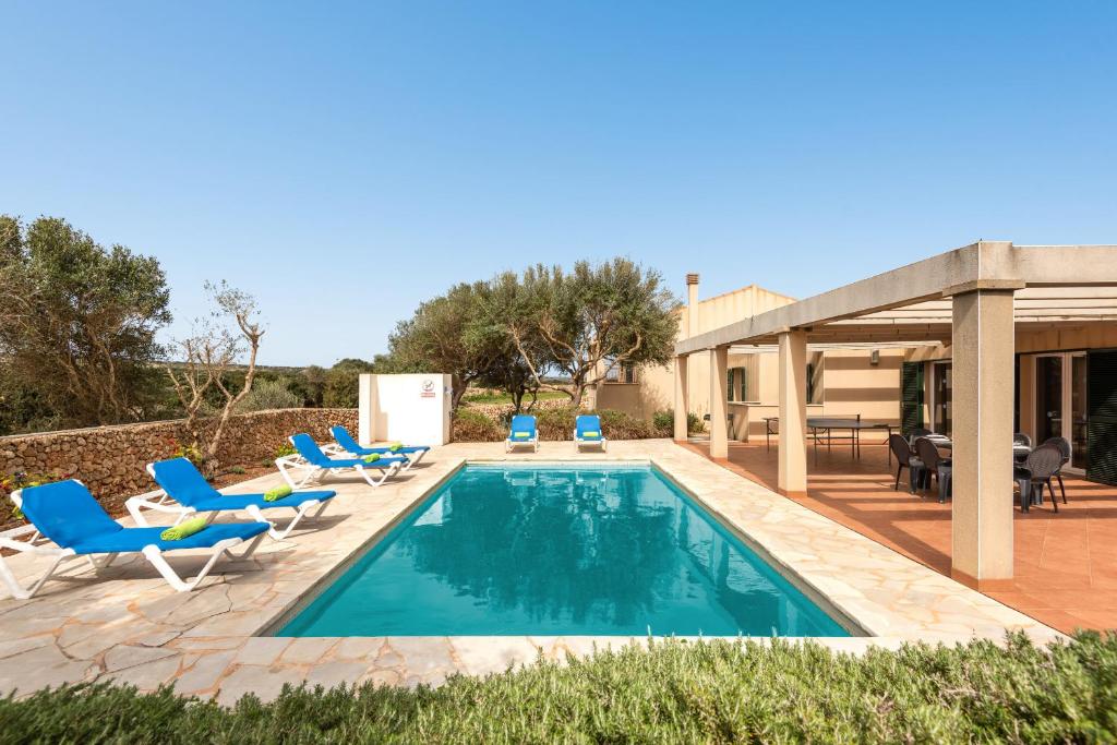 uma piscina com espreguiçadeiras e uma casa em Villa Menorca Flomertor 2 by Mauter Villas em Cala en Blanes