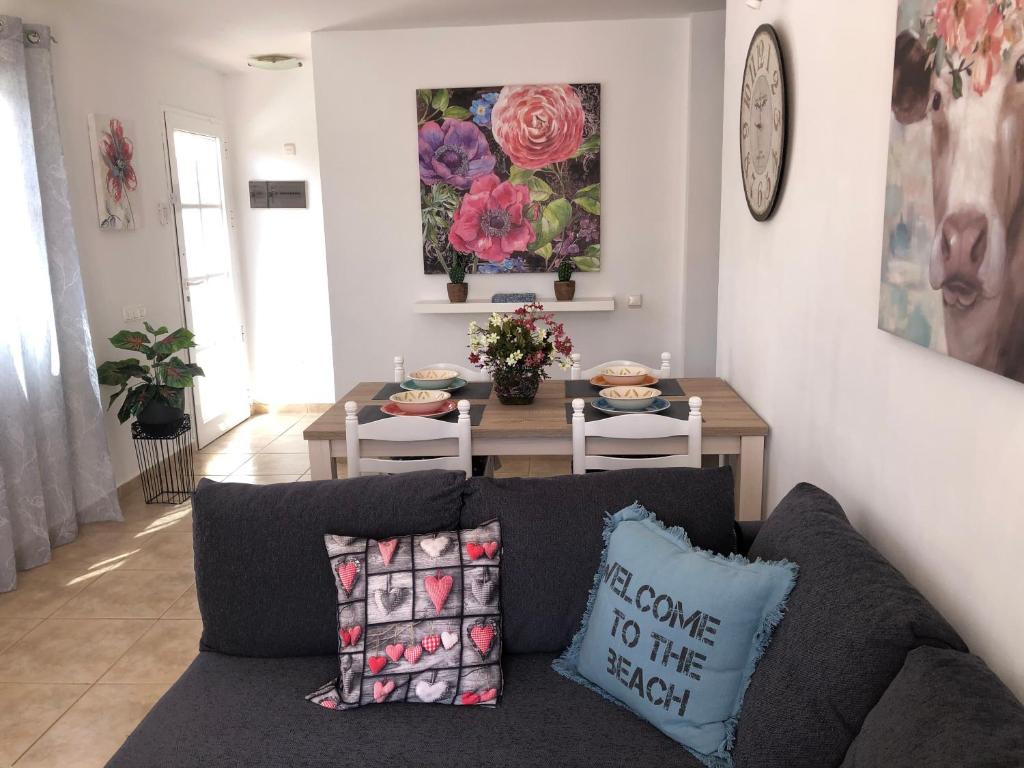 a living room with a couch and a table at Villa Las Coquetas "Optical Fiber" in Caleta De Fuste