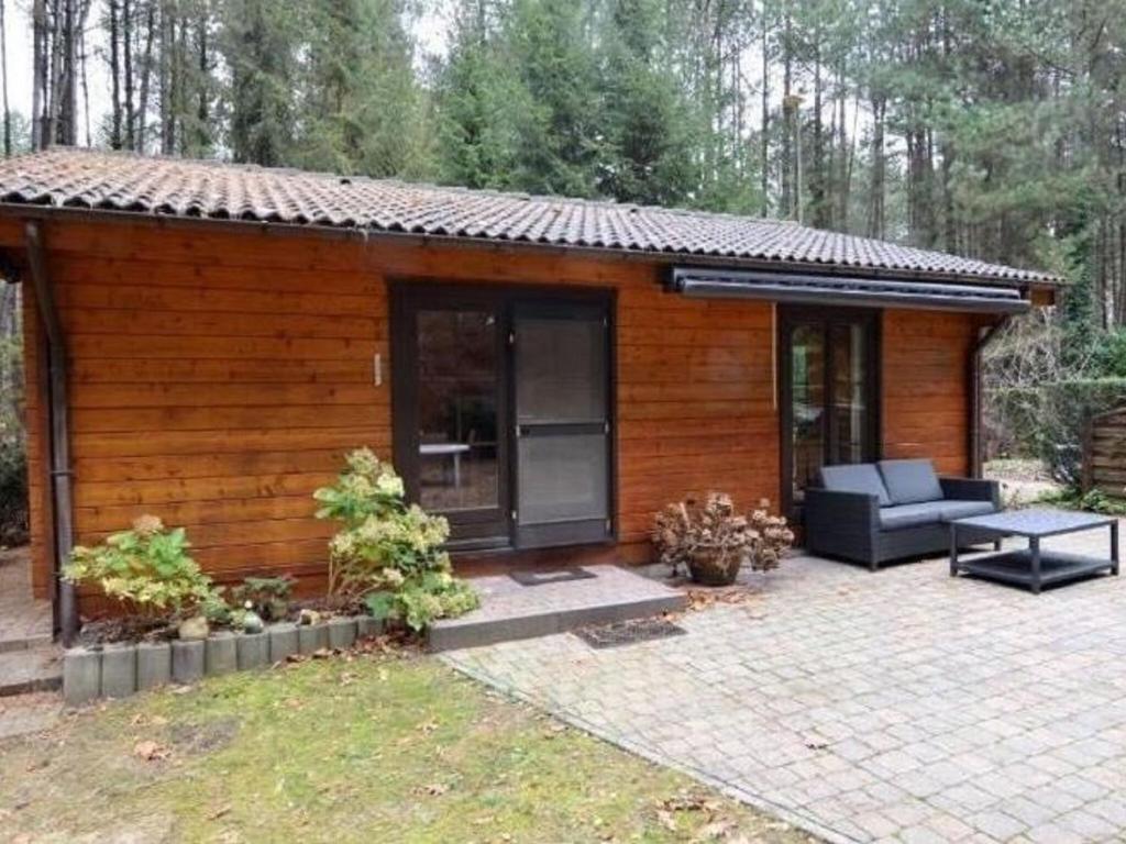 Cabaña pequeña con sofá y patio en Chalet in a peaceful location near Nijlen, en Nijlen