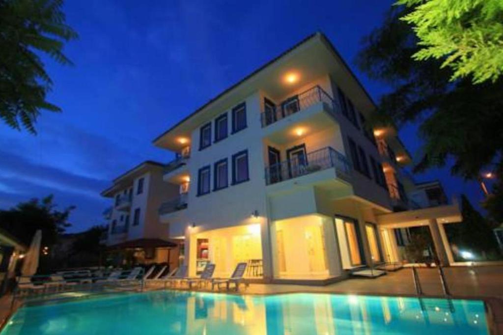 a large house with a swimming pool in front of it at Marigold Otel in Çeşme