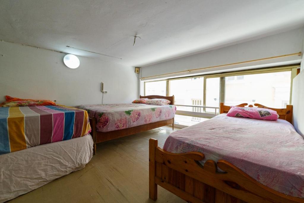 - une chambre avec 2 lits et une fenêtre dans l'établissement Deligianni&Notara st Guest House, à Athènes