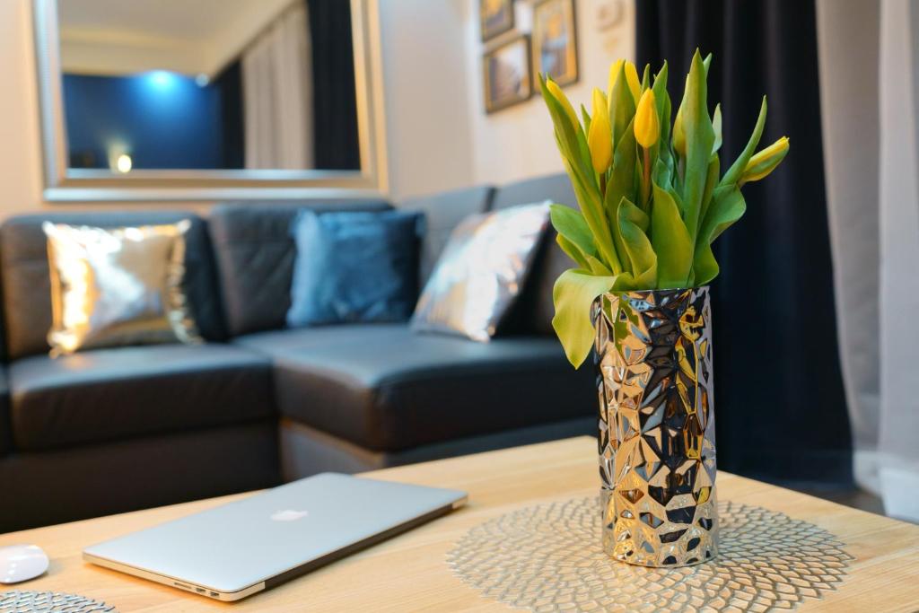 a vase with flowers on a table in a living room at Apartament Oaza in Kościelisko