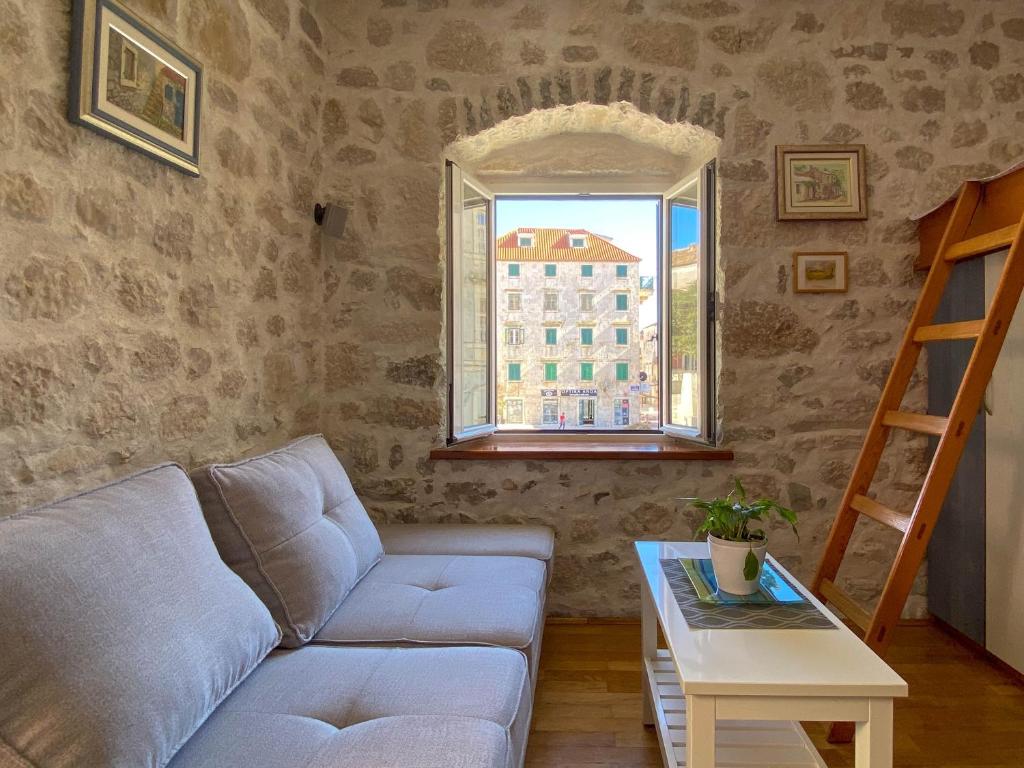 a living room with a couch and a window at City center apartment Roza in Makarska