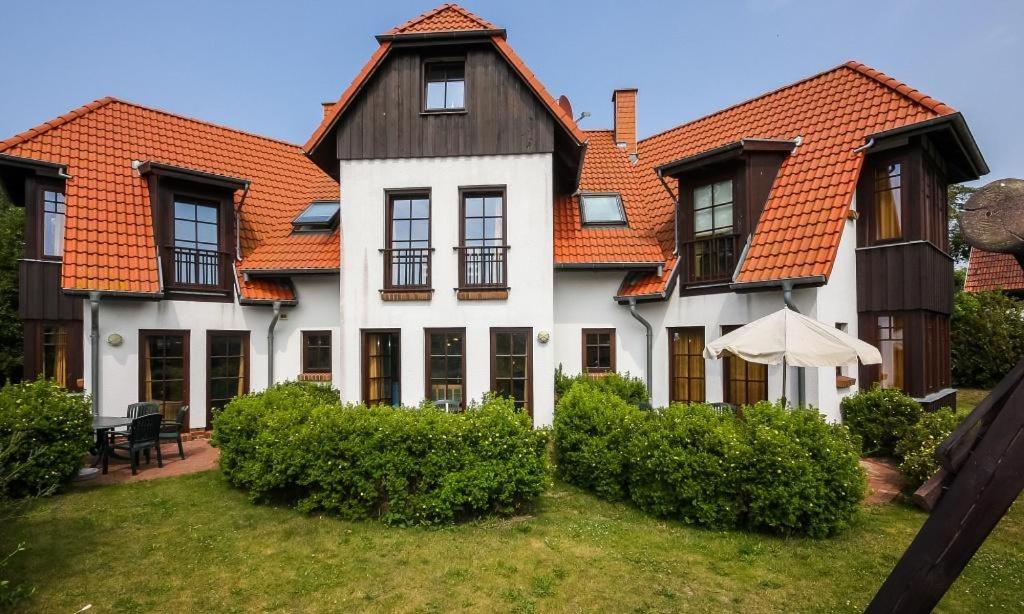 una gran casa blanca con techo naranja en Bootsanleger, Landhaus Haven Höövt, en Ahrenshoop