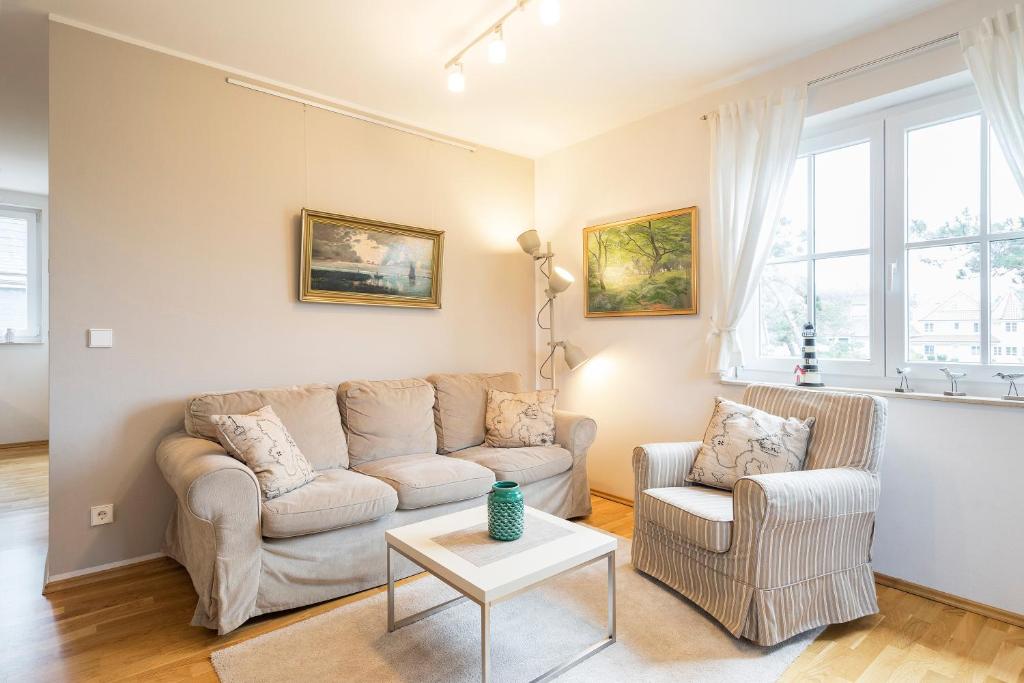 a living room with a couch and two chairs at Strandleben 10 - Louis Douzette in Ahrenshoop