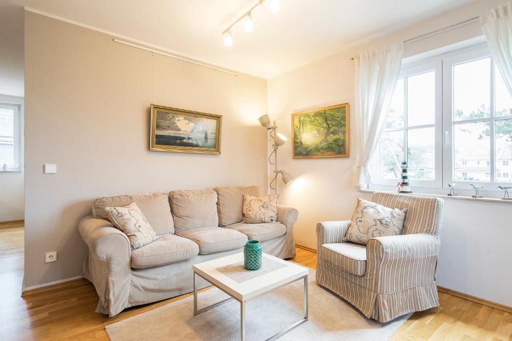 a living room with a couch and two chairs at Strandleben 10 - Louis Douzette in Ahrenshoop