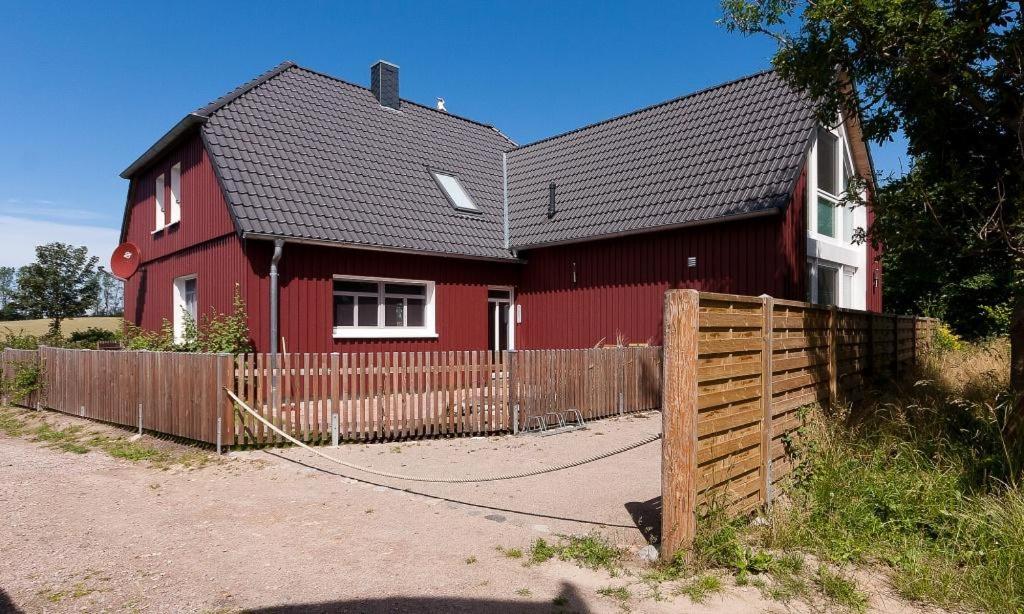 a red house with a fence in front of it at Kapitänshaus - Atelier in Ahrenshoop