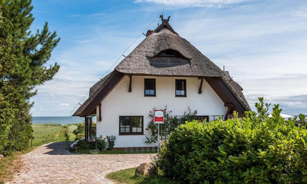a large white house with a thatched roof at Haus am Bodden 02 in Ahrenshoop