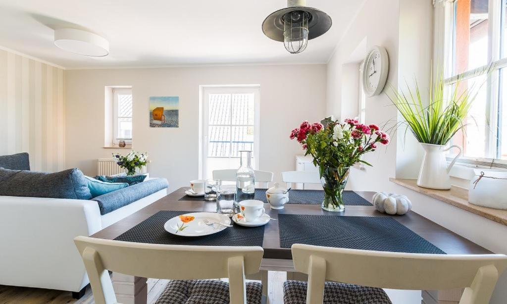 a dining room and living room with a table and chairs at Darßzeit in Ahrenshoop