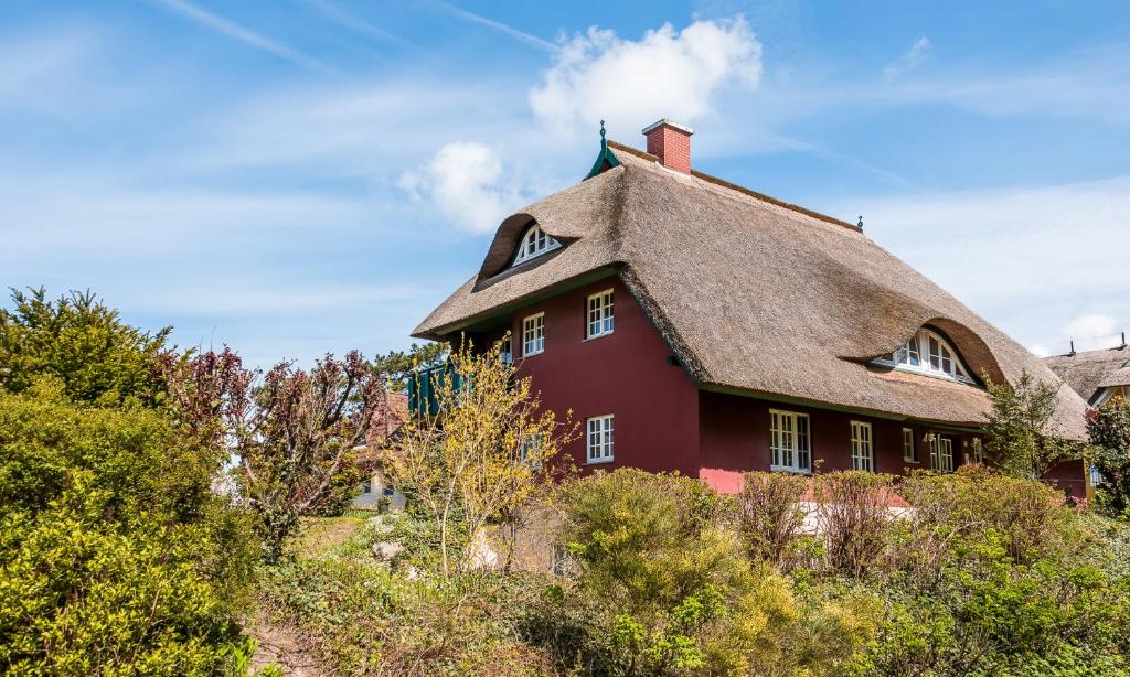 a large red house with a thatched roof at Strandidyll in Ahrenshoop