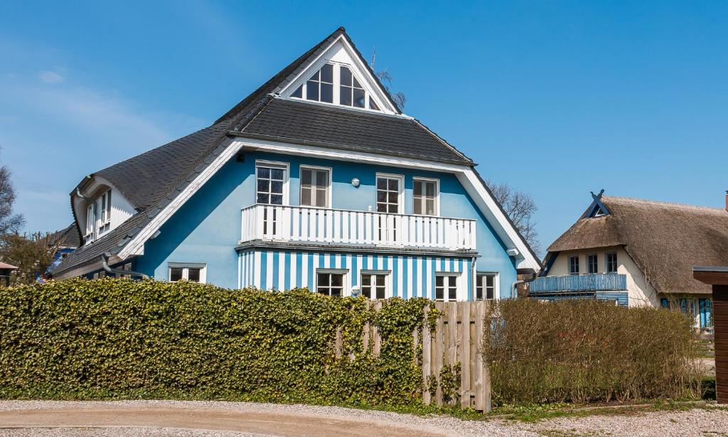 une maison bleue et blanche avec un toit noir dans l'établissement Madlen, à Ahrenshoop