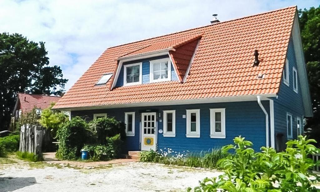 een blauw huis met een oranje dak bij Darßer Smuggler Hus 3 in Wieck