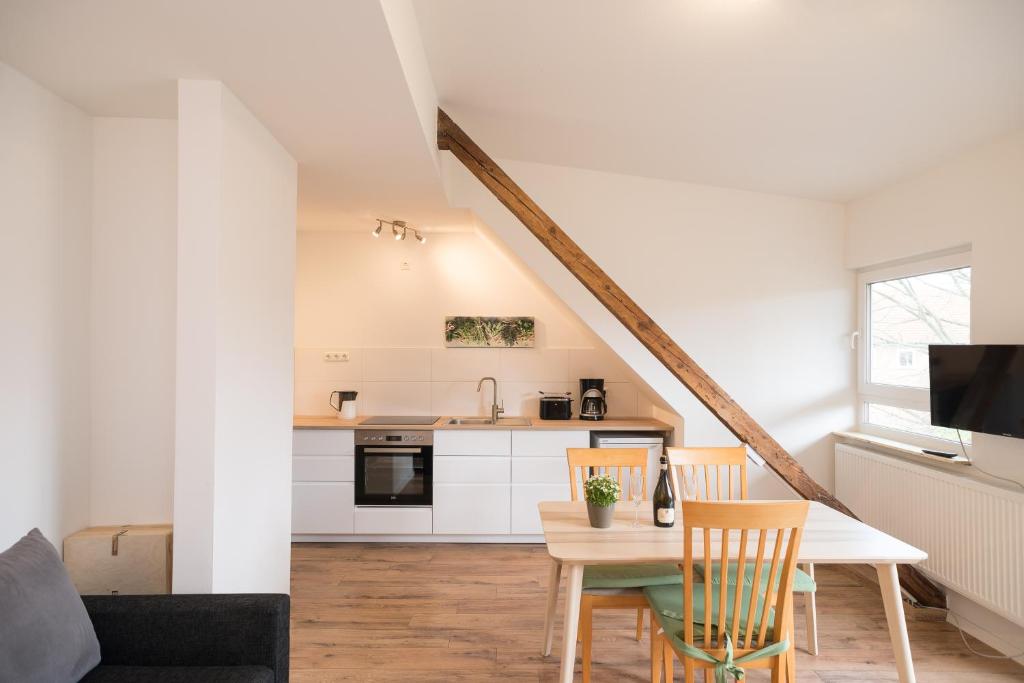 cocina y sala de estar con mesa y sillas en FeWo Engler Lüneburg Gellersstraße, en Lüneburg