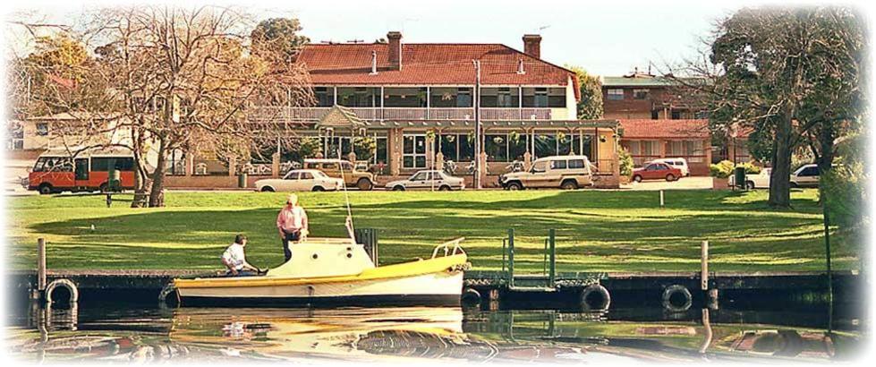 a boat in the water in front of a building at Denmark Hotel in Denmark