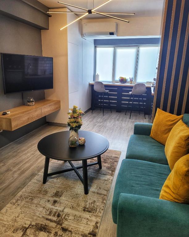 a living room with a green couch and a table at Apartament Deluxe cu parcare gratuită, lângă Arena Mall in Centru Bacău - ideal pentru cupluri sau business in Bacău