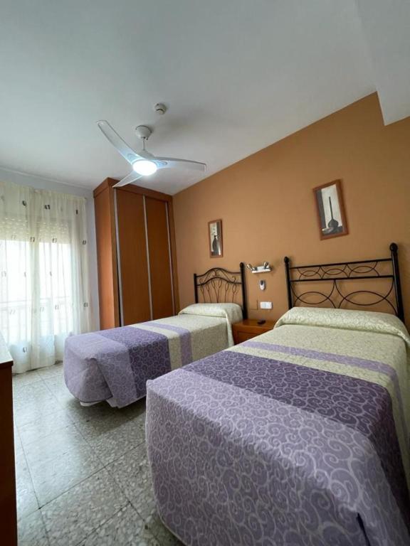 Habitación de hotel con 2 camas y ventilador de techo. en H Arkanta en Arganda del Rey