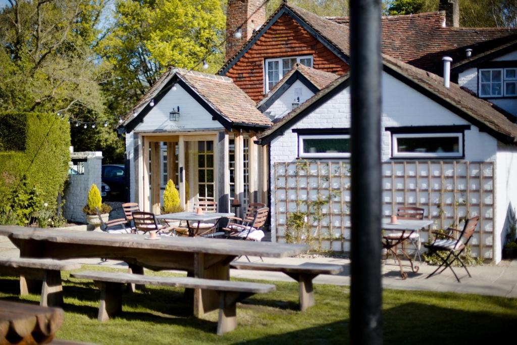 una mesa de picnic frente a una casa en The Old House Inn, en Burstow