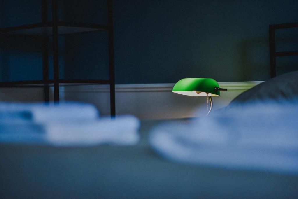 a green and white lamp sitting on a bed at Atelier Boutique Hotel in Shkodër