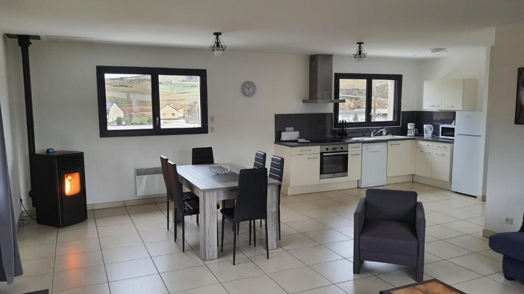 a kitchen with a table and chairs in a room at Appartement tout confort au milieu de la Margeride in Châteauneuf-de-Randon