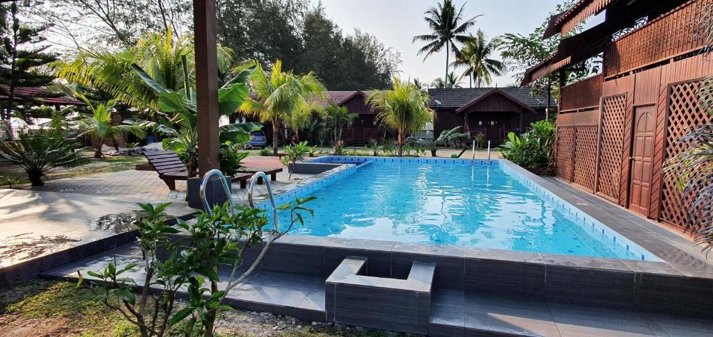 una piscina frente a una casa en Bayu Beach Penarek, en Kampung Penarik
