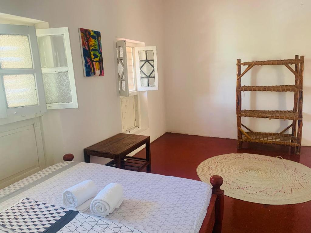 a bedroom with a bed and a table and a chair at Zava House Stone town in Zanzibar City