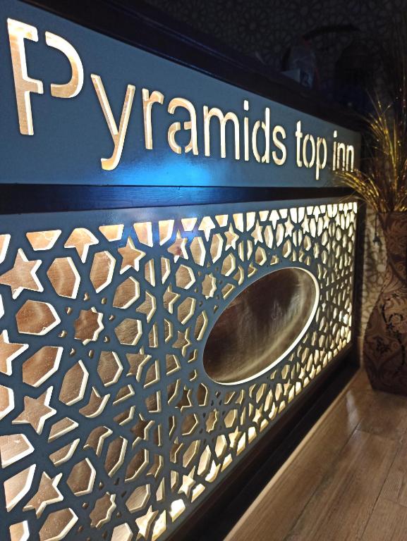 a sign for a thrift store with a metal gate at Pyramids Top Inn in Cairo