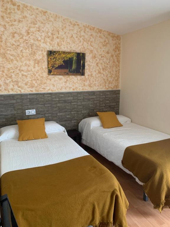 a room with two beds in a room at La Luna in Aldeanueva del Camino