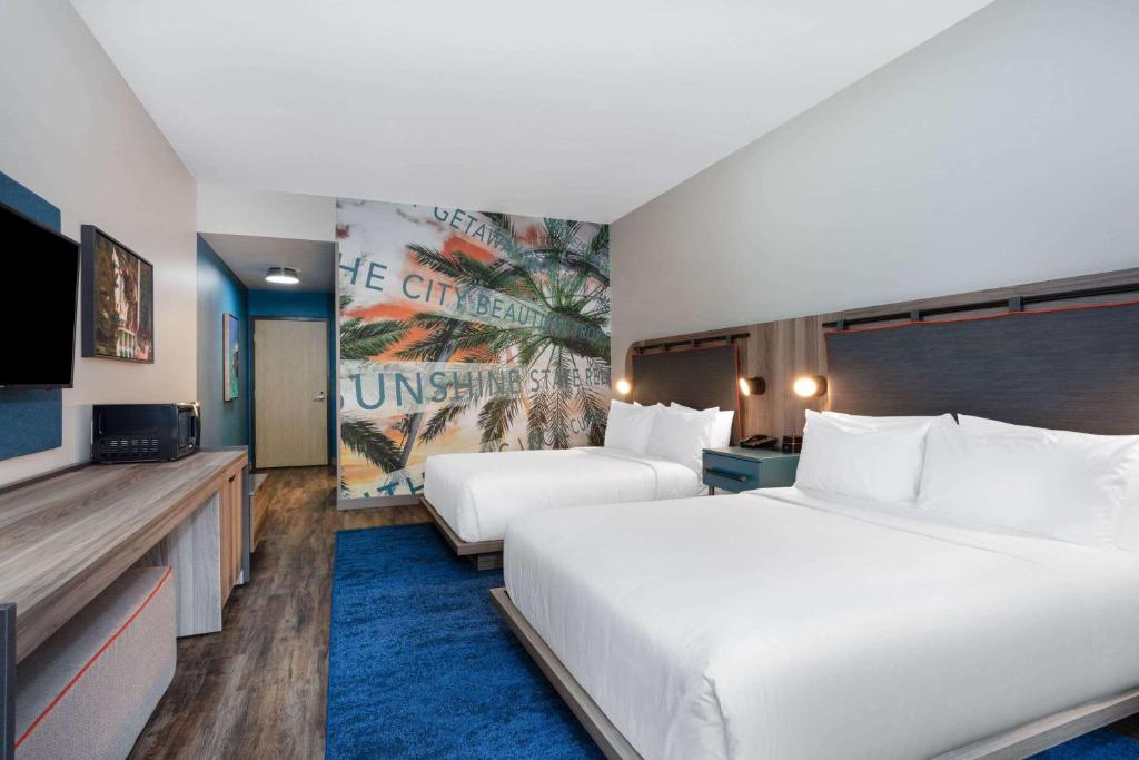 A bed or beds in a room at TRYP by Wyndham Orlando