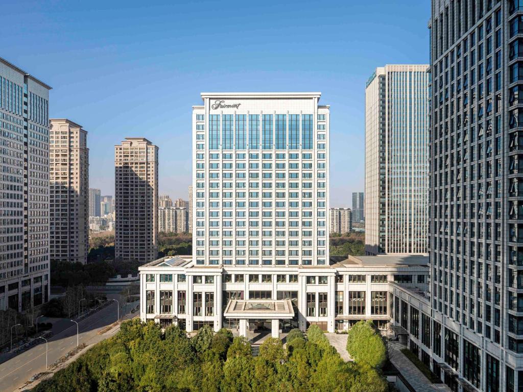 een groot gebouw in een stad met hoge gebouwen bij Fairmont Wuhan in Wuhan