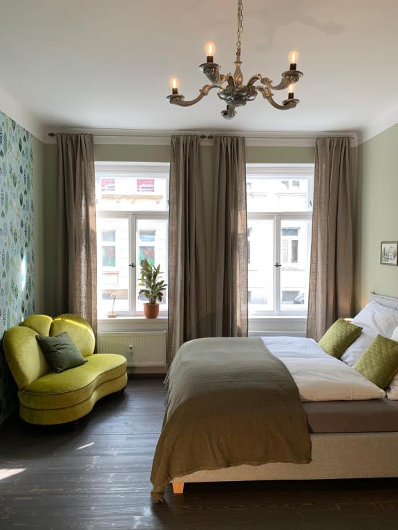 ein Schlafzimmer mit einem Bett und einem gelben Stuhl in der Unterkunft Ferienwohnung HIRZELZEIT in Leipzig