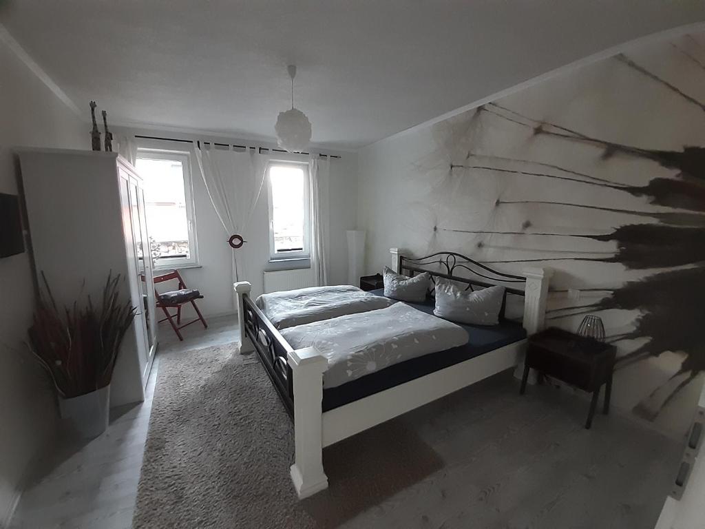Ferienwohnung John في إيزيناخ: غرفة نوم بسرير في غرفة بيضاء