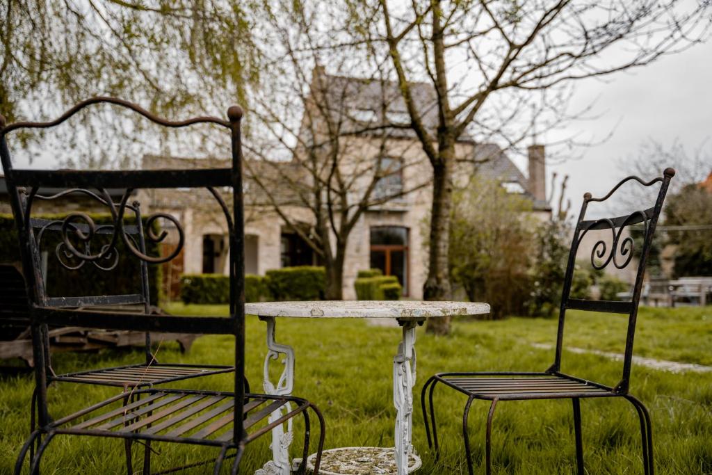 twee stoelen en een tafel en een tafel en twee stoelen bij Villa Ghysbrecht in Alveringem