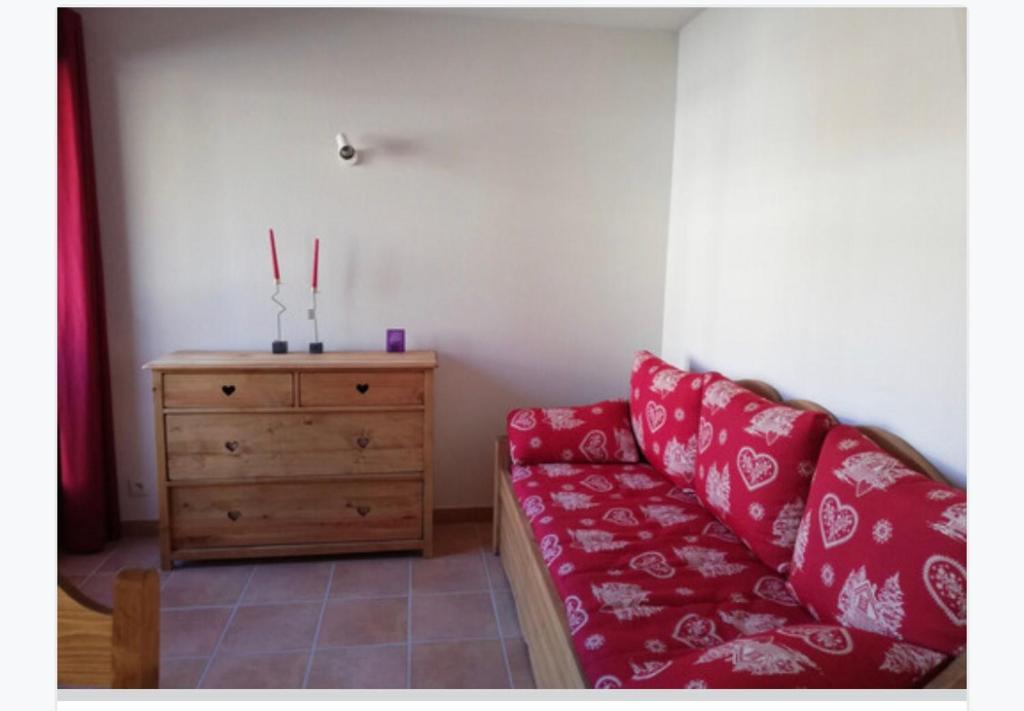 ein Wohnzimmer mit einer roten Couch und einer Holzkommode in der Unterkunft Superbe studio praloup 1600 in Pra-Loup