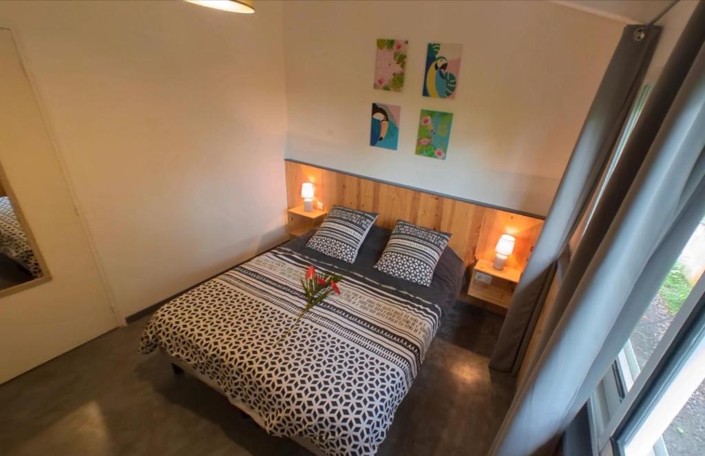 una camera da letto con un letto con due cuscini di Les gîtes de Bunel a Les Abymes