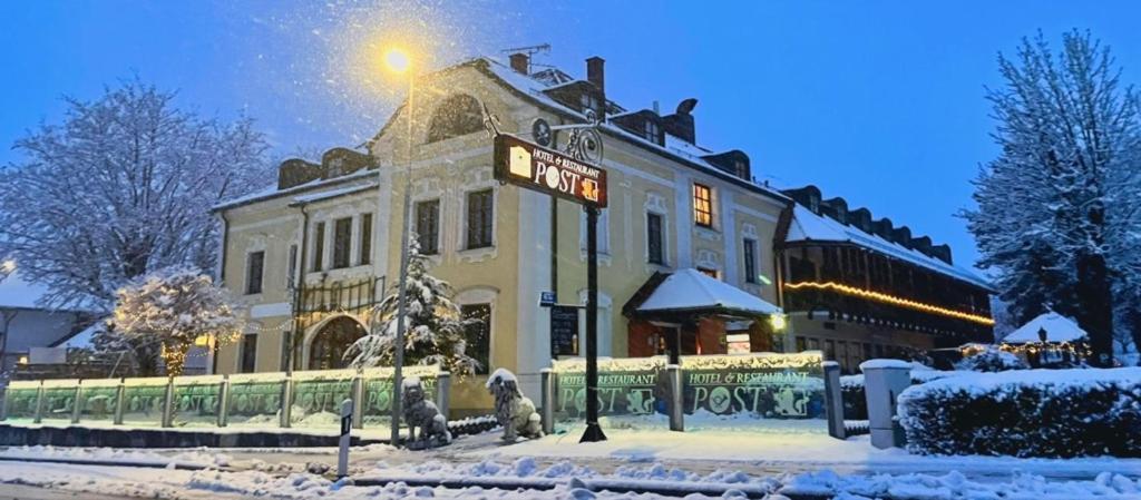 ein Gebäude mit einem Schild im Schnee in der Unterkunft Hotel und Restaurant Post Prienbach in Stubenberg
