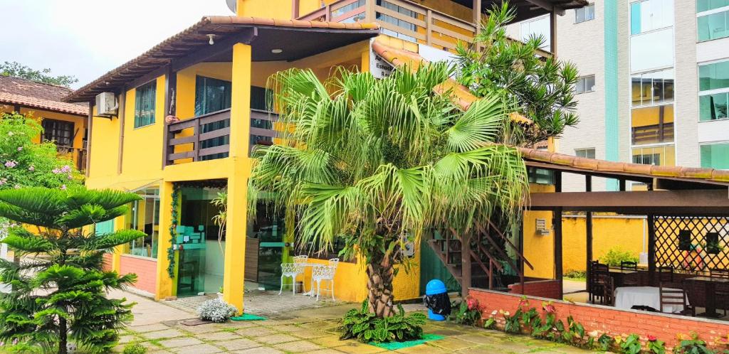 a palm tree in front of a building at Pousada da Baleia in Rio das Ostras