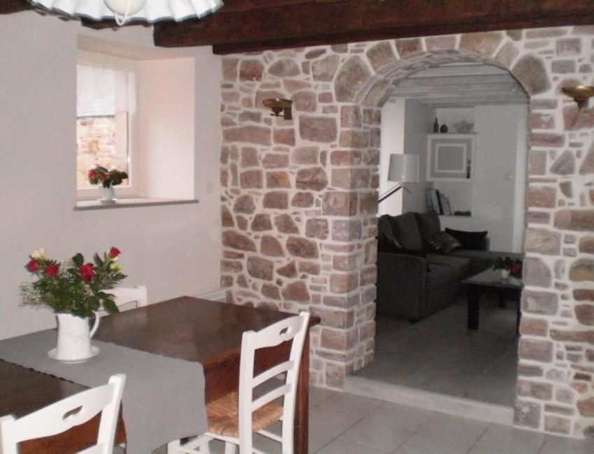 cocina y sala de estar con pared de piedra en Maison Le Grès Rose, en Erquy