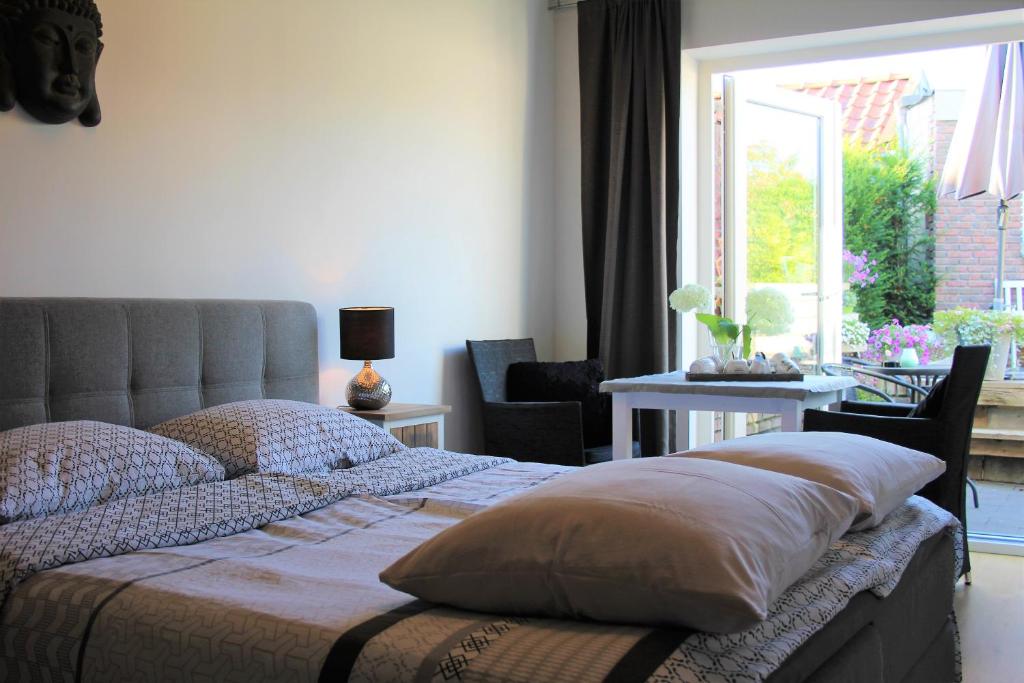 a bedroom with a bed and a table and a window at Slapen & Smullen in Swalmen