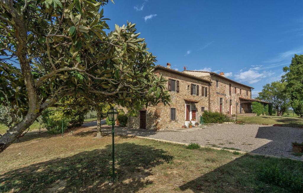 een oud stenen huis met een boom ervoor bij Tenuta San Vito In Fior Di Selva in Montelupo Fiorentino