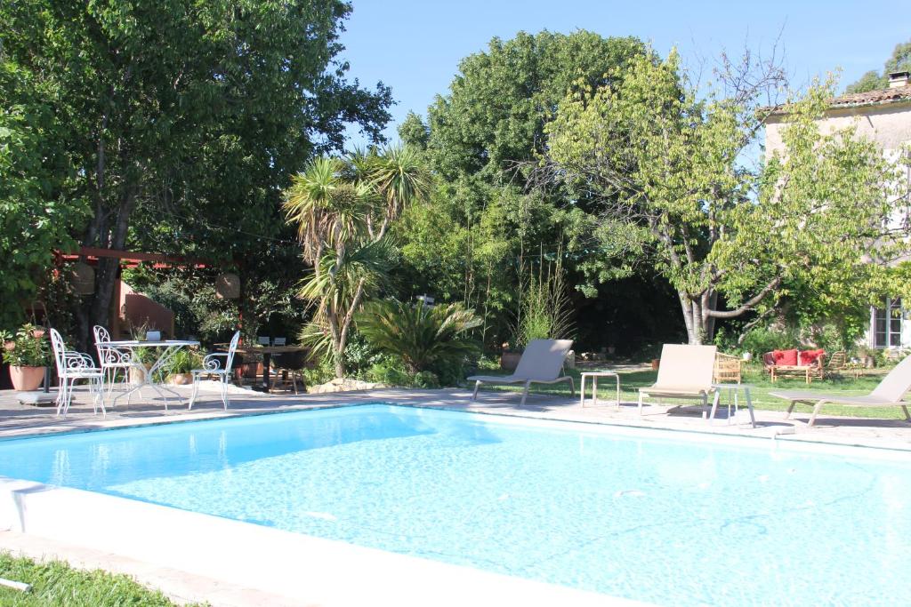 einen Pool mit Stühlen und einem Tisch in der Unterkunft Domaine Sesquier Mas d'exception Pivoine in Mèze