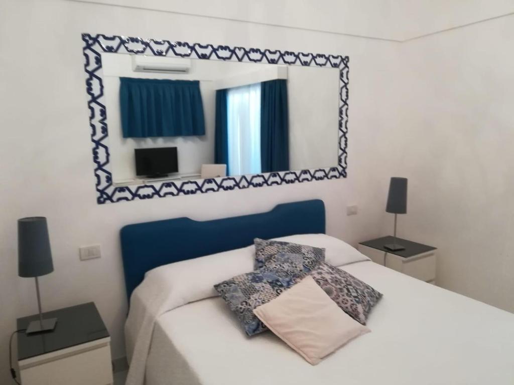 a bedroom with a bed with a mirror on the wall at Casa Vacanza Al Centro di Capri in Capri
