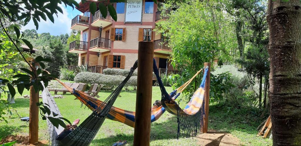 a couple of hammocks in front of a building at Riacho Das Pedras Pousada in Gonçalves