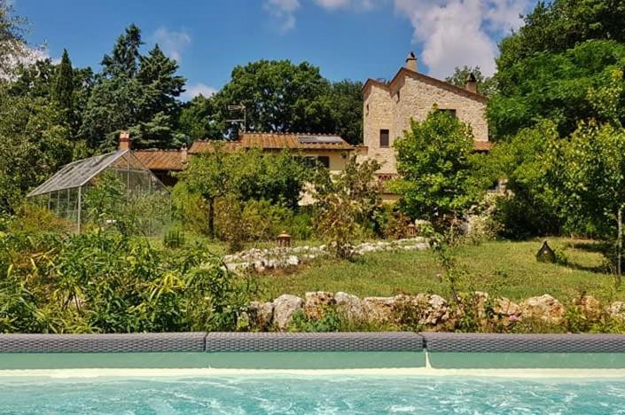 uma casa e uma piscina em frente a uma casa em B&B and Wellness Il Pomario di Montepiglio Resort Naturista em Amelia