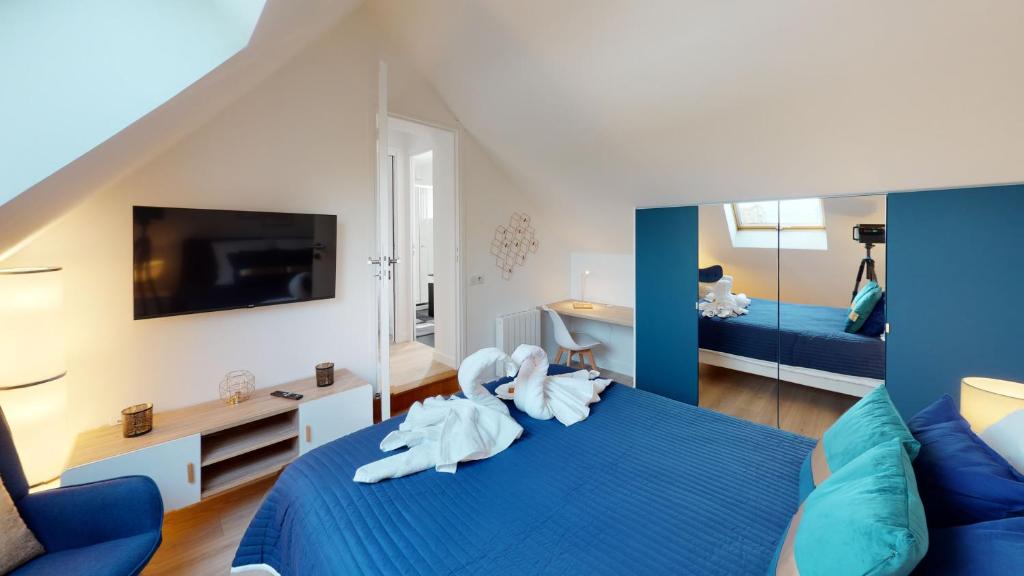 a bedroom with towels on a blue bed at PARIS HOUSE in Villejust