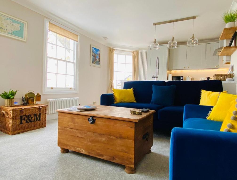 a living room with a blue couch and a coffee table at Nickleby Nook By the Sea - Meters to the Beach! in Broadstairs