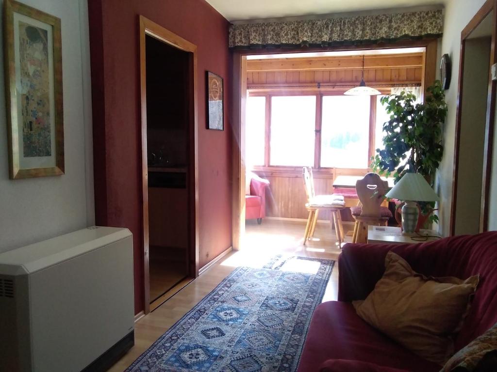 a living room with a couch and a room with a window at Appartements direkt am See in Grundlsee