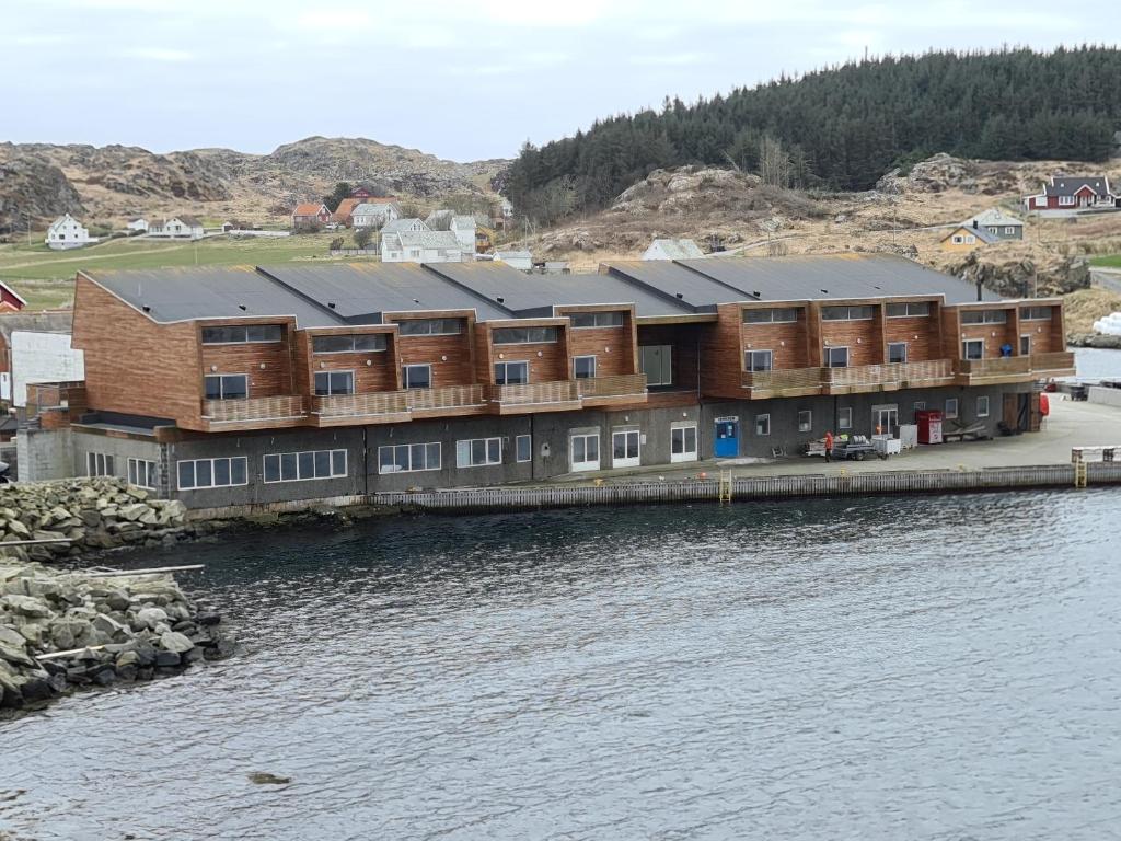 un gran edificio junto a una masa de agua en Utsira Overnatting - Bølgen, en Utsira