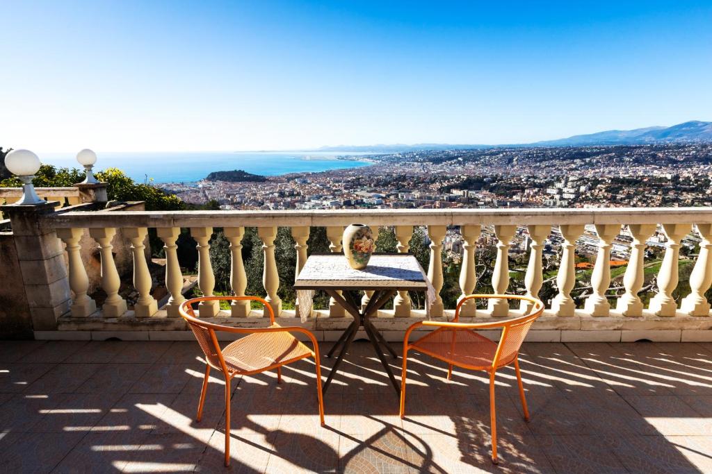 a table and two chairs on a balcony with a view at Observatoire in Nice