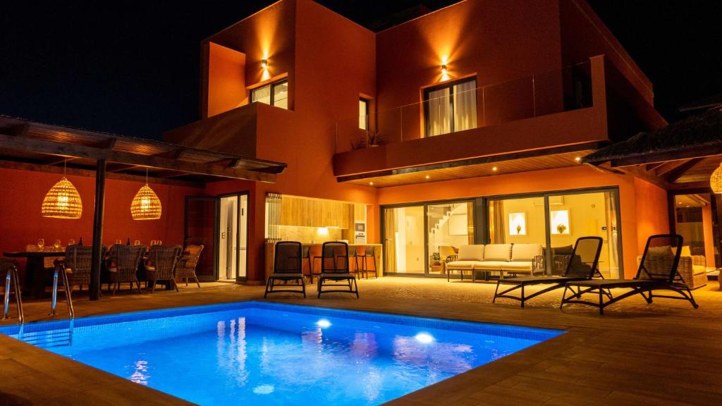ein Haus mit Swimmingpool bei Nacht in der Unterkunft Villa privada de lujo con piscina, Sabi Sabi in Corralejo