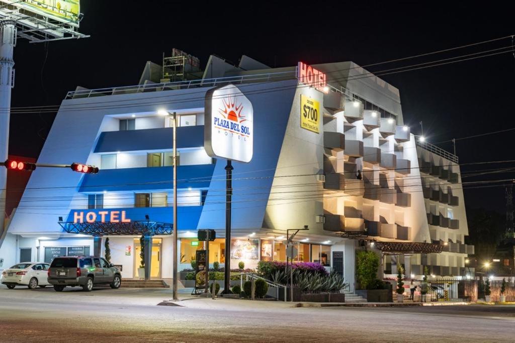 un hotel por la noche con un semáforo delante de él en Hotel Plaza del Sol, en Hermosillo